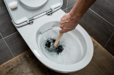 Plugged toilet. Brown toilet water.