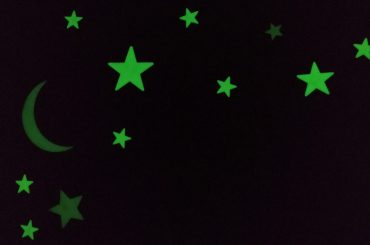 Glow in the dark stickers on a wall and ceiling.