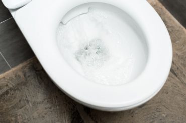 A toilet is gurgling at the end of a flush.
