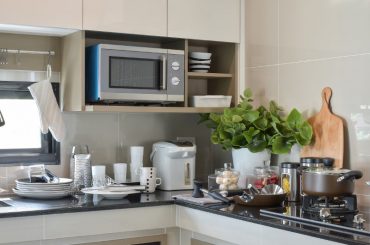 Microwave in a kitchen cabinet.