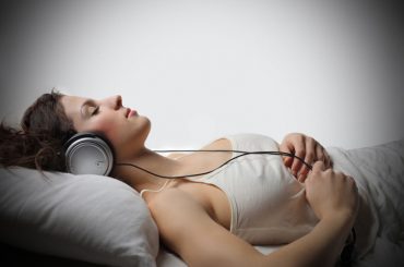 A woman sleeping with headphones on her head.