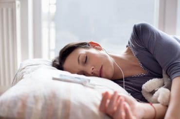 Woman listening to music while sleeping.