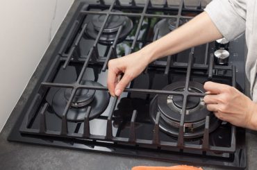 Putting back stove grates after they were washed in a dishwasher.