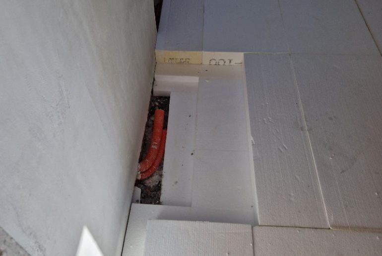 EPS 100 rigid insulation boards installed on a prepared floor base, providing thermal insulation and load support beneath the concrete slab.