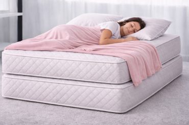 Young woman sleeping on two mattresses that are stacked one on top of the other.