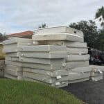 Different types of mattresses stored stacked outside.