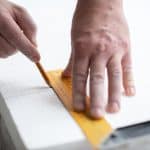 Measuring and marking EPS polystyrene foam to ensure accurate cutting and proper fit during installation.